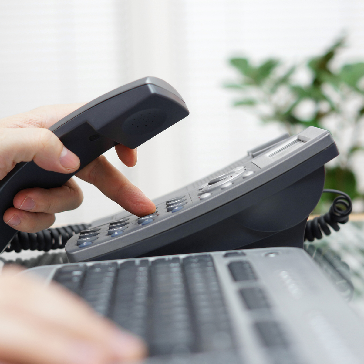 Someone dialing a phone in an office